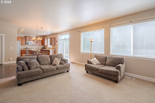 carpeted living room featuring a chandelier