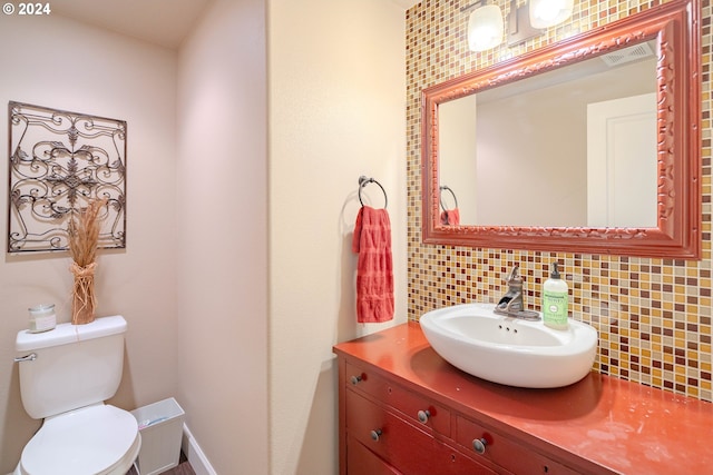 bathroom featuring backsplash, toilet, and vanity