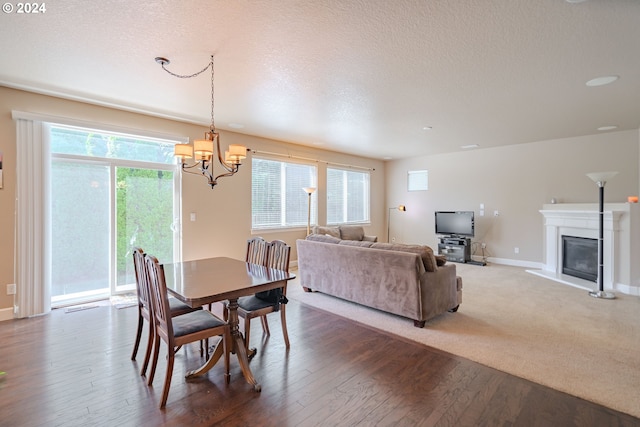 15003 NE 102nd St, Vancouver, WA 98682 - dining space with a chandelier, dark wood-style flooring, a textured ceiling, a glass covered fireplace, and baseboards
