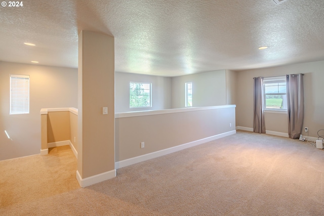 carpeted empty room featuring a textured ceiling