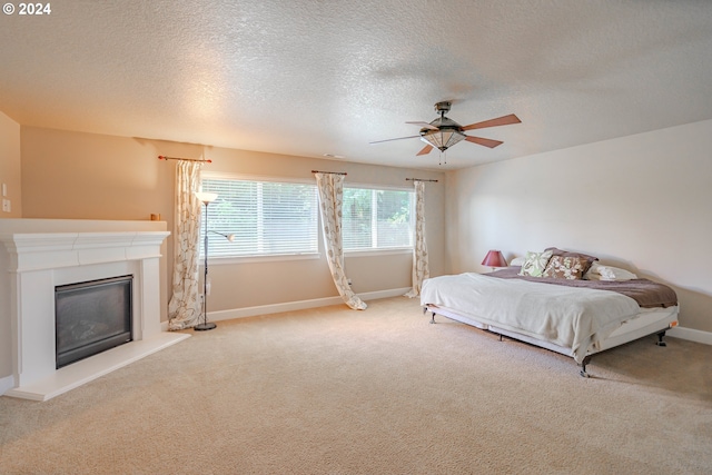 carpeted bedroom featuring a textured ceiling and ceiling fan