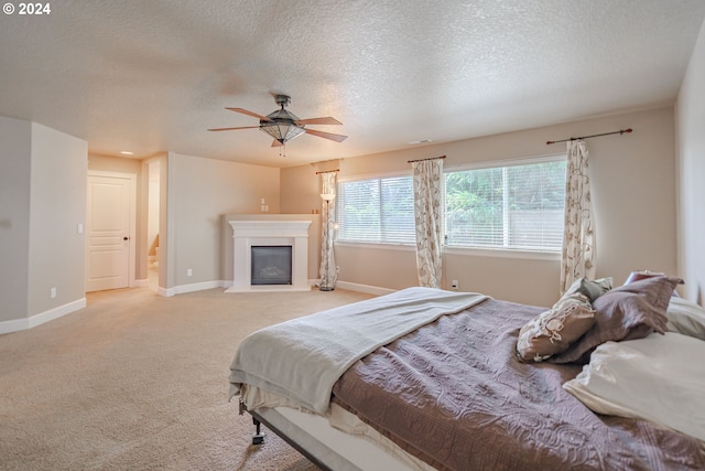 carpeted bedroom featuring a textured ceiling and ceiling fan