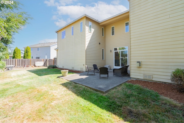 rear view of property featuring a lawn and a patio area