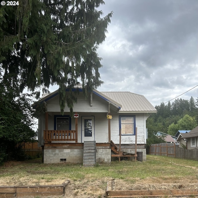 bungalow with covered porch and a front lawn