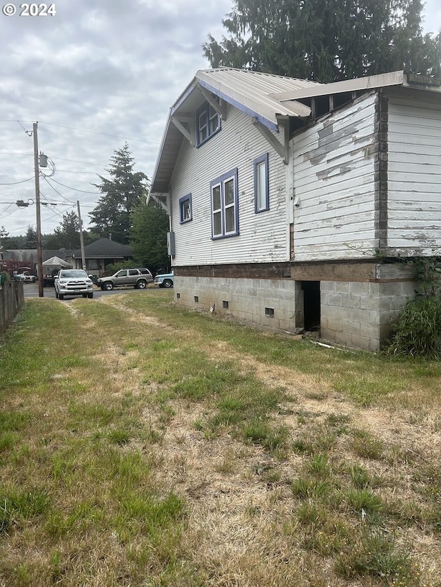 view of side of property with a lawn