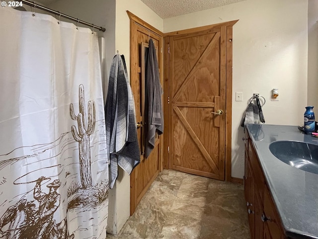 bathroom with vanity and a textured ceiling