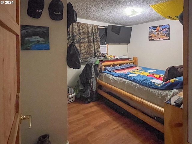 bedroom featuring wood-type flooring and a textured ceiling