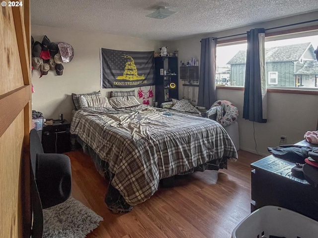 bedroom with hardwood / wood-style flooring and a textured ceiling