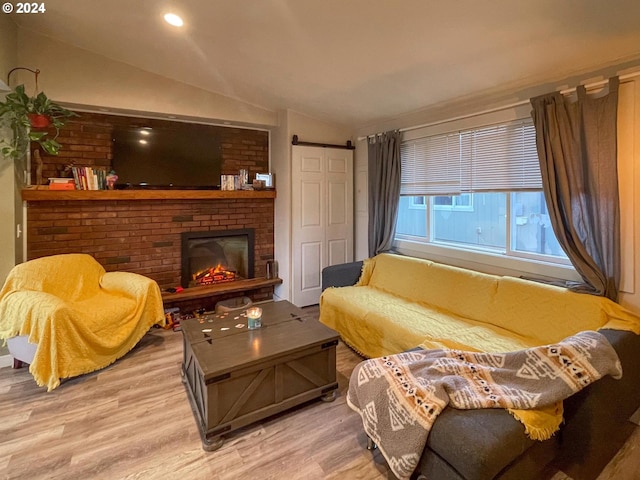 sitting room with hardwood / wood-style flooring, lofted ceiling, and a fireplace