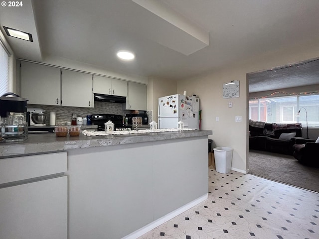 kitchen featuring white refrigerator, tasteful backsplash, black electric range oven, and sink