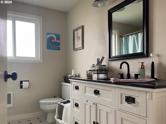 bathroom featuring vanity, a textured ceiling, and toilet