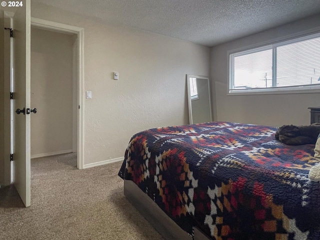 bedroom with light carpet and a textured ceiling