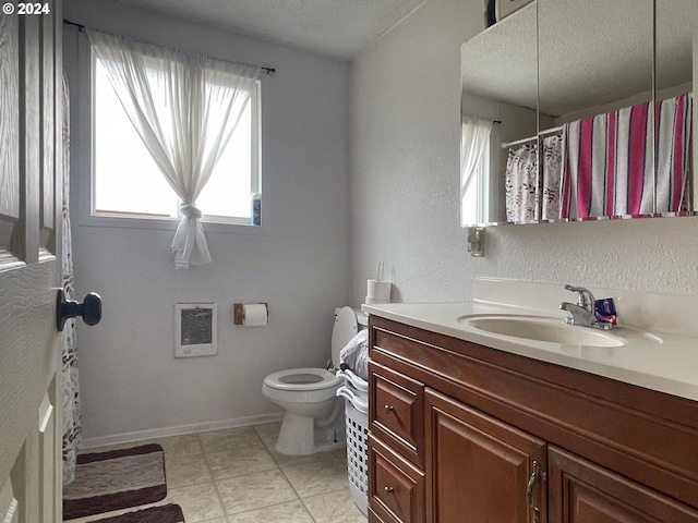 bathroom featuring tile patterned floors, heating unit, a textured ceiling, toilet, and vanity