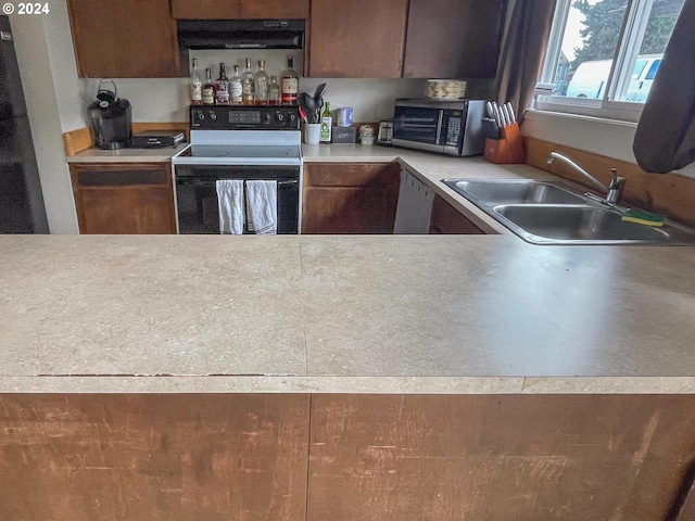 kitchen featuring range with electric stovetop, dishwashing machine, sink, and extractor fan