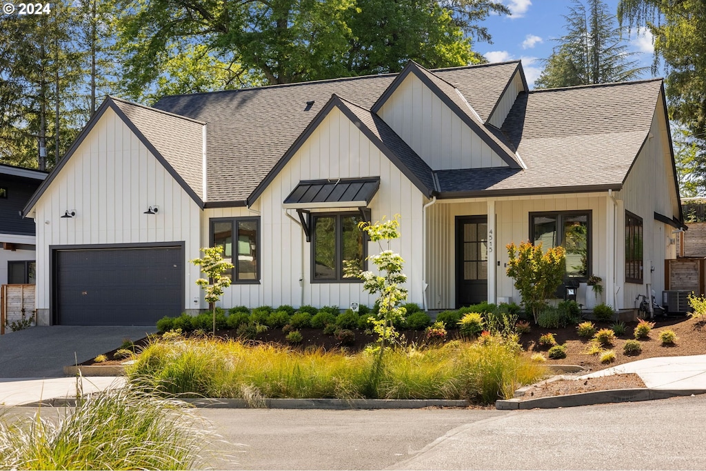 modern farmhouse style home featuring central AC and a garage