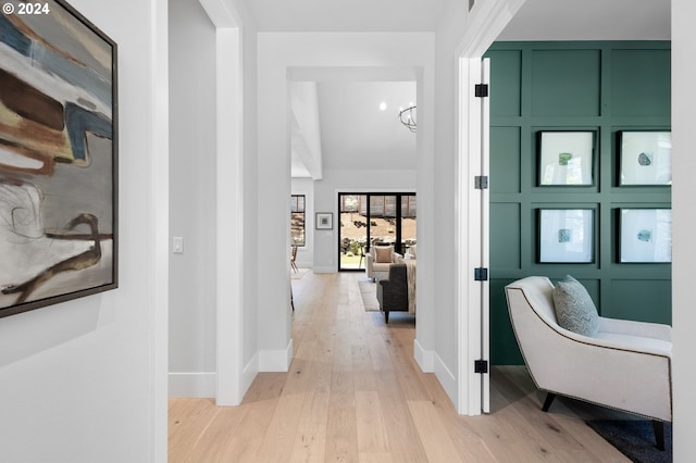 hallway featuring a chandelier and light hardwood / wood-style floors