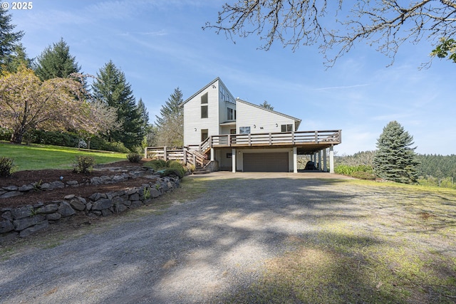 view of side of home with a garage, gravel driveway, a deck, stairway, and a carport