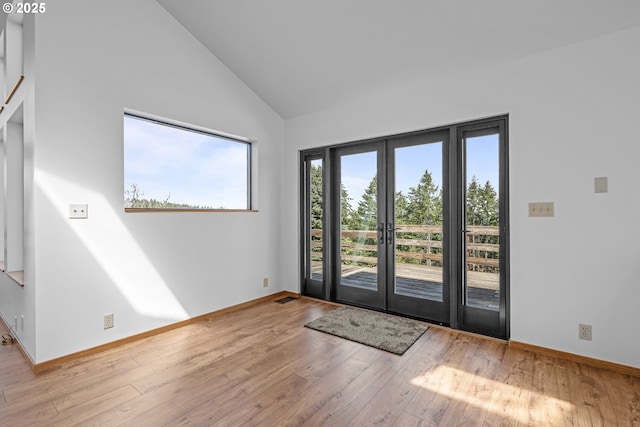 entryway with baseboards, french doors, high vaulted ceiling, and hardwood / wood-style floors
