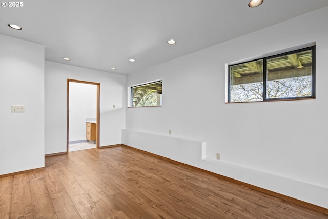 unfurnished room with baseboards, recessed lighting, and hardwood / wood-style floors