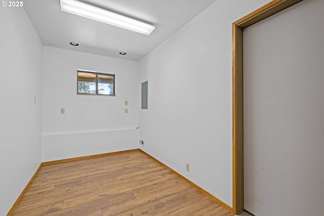 spare room with electric panel and wood finished floors