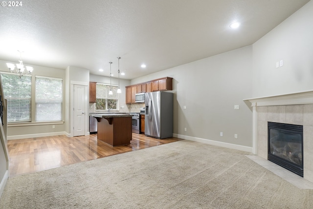 kitchen featuring a center island, hanging light fixtures, a breakfast bar area, light hardwood / wood-style floors, and stainless steel appliances