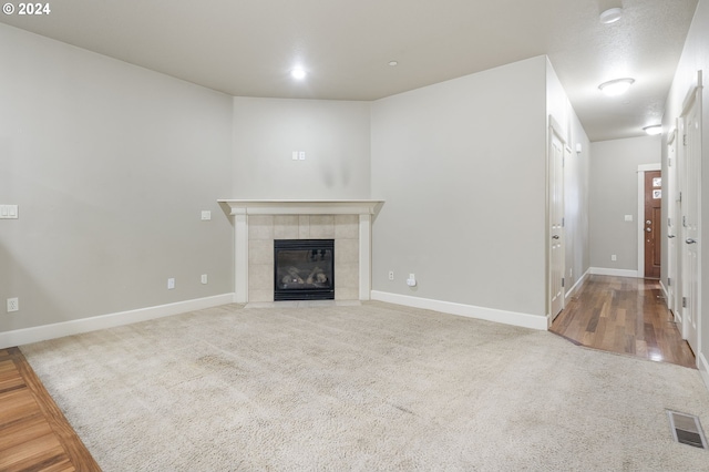 unfurnished living room featuring a fireplace and hardwood / wood-style flooring