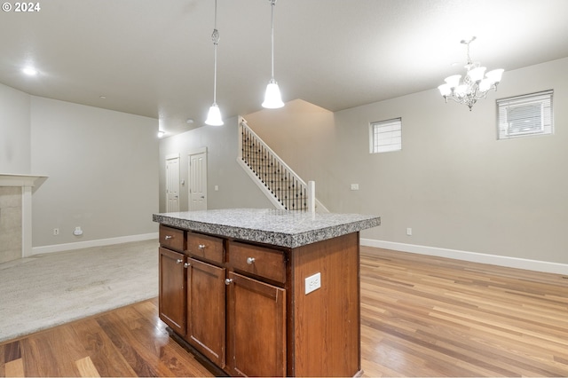 kitchen with pendant lighting, a center island, light hardwood / wood-style floors, and an inviting chandelier