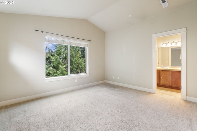 carpeted empty room with lofted ceiling and sink