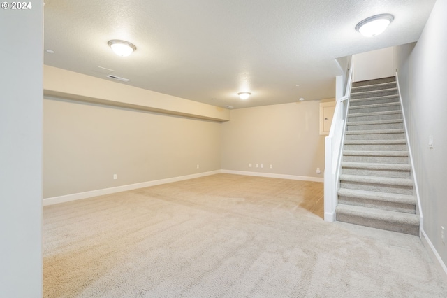 basement with light carpet and a textured ceiling