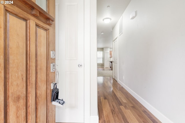 hallway with hardwood / wood-style floors