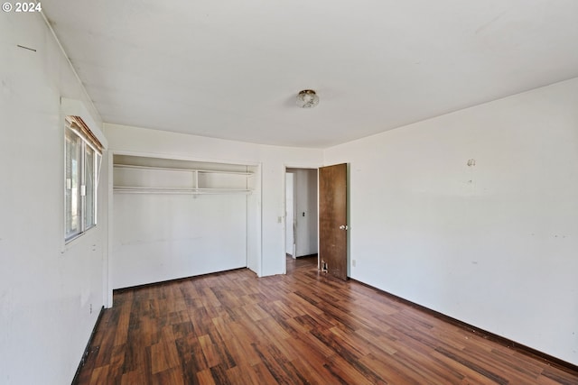 unfurnished bedroom featuring a closet and dark hardwood / wood-style flooring