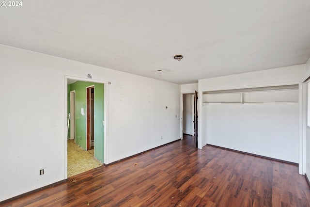 unfurnished bedroom featuring a closet and dark hardwood / wood-style flooring