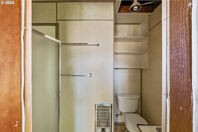 bathroom featuring heating unit and toilet