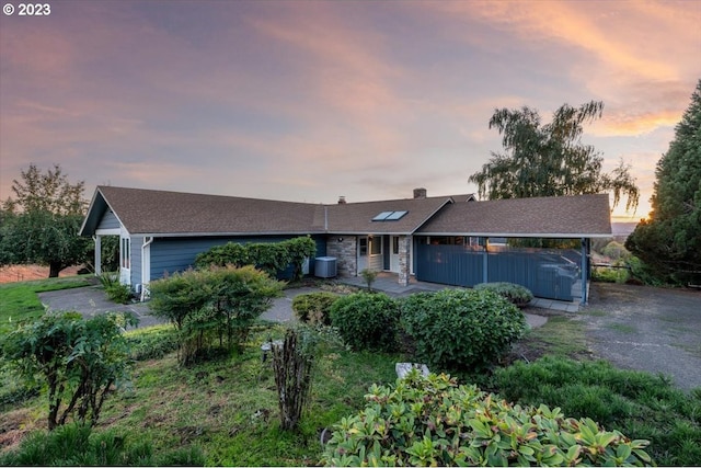 ranch-style house featuring central air condition unit and a garage