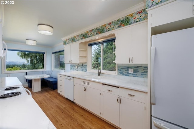 kitchen with light hardwood / wood-style floors, white appliances, sink, and a wealth of natural light