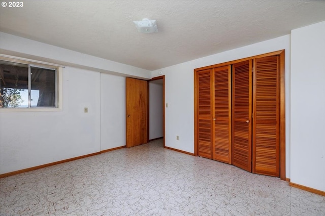 unfurnished bedroom featuring a textured ceiling, light tile patterned floors, and a closet