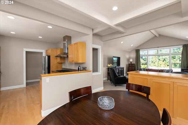 dining room featuring light hardwood / wood-style flooring and vaulted ceiling with beams