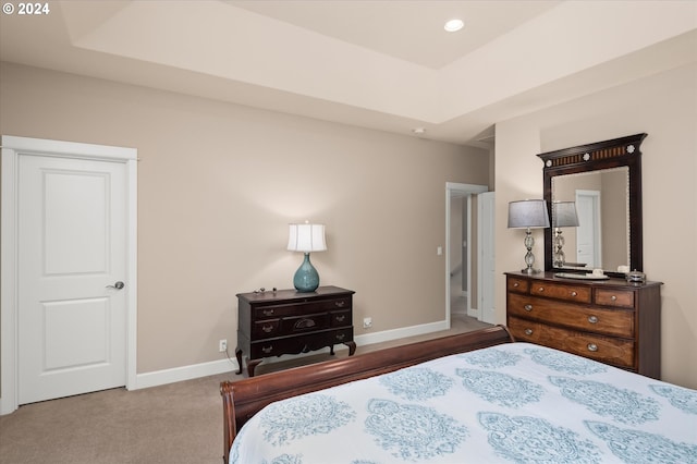 carpeted bedroom with a tray ceiling