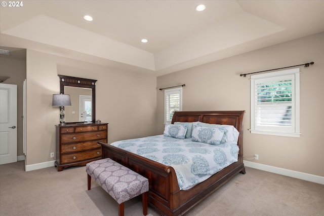 carpeted bedroom featuring a tray ceiling