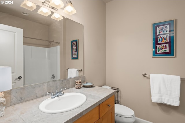 bathroom with walk in shower, vanity, and toilet