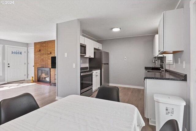 kitchen with white cabinets, dark hardwood / wood-style flooring, stainless steel appliances, and sink