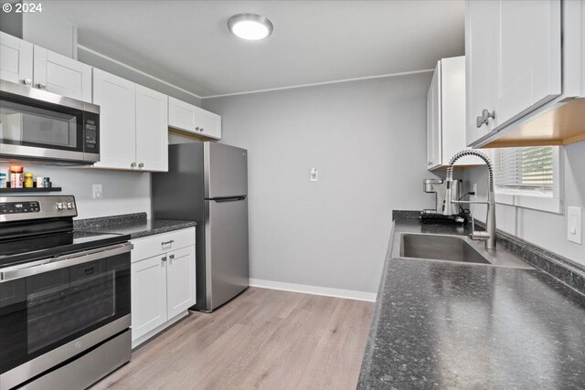 kitchen with light hardwood / wood-style flooring, stainless steel appliances, sink, and white cabinetry