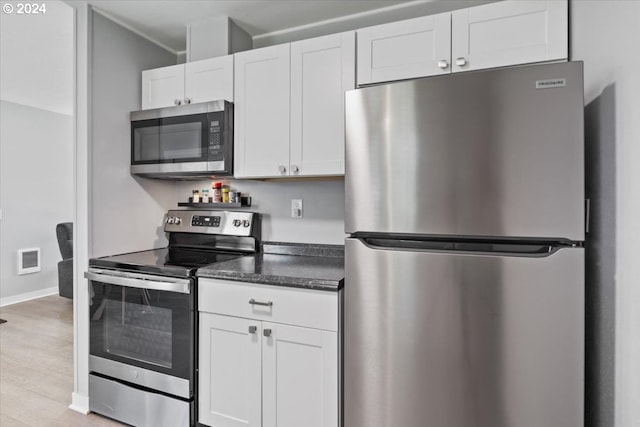 kitchen featuring appliances with stainless steel finishes, light hardwood / wood-style floors, and white cabinetry