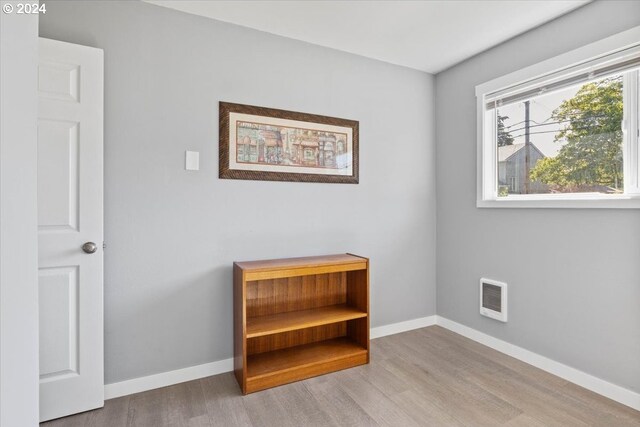 interior space featuring wood-type flooring and heating unit