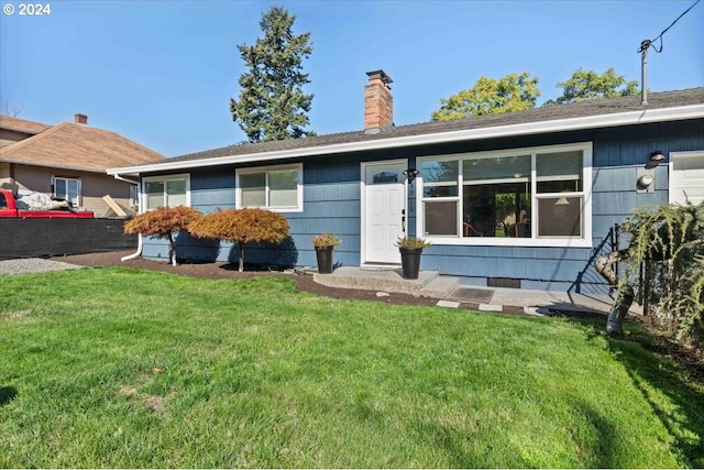 view of front of home with a chimney and a front lawn