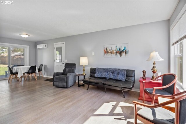 living room with hardwood / wood-style flooring and a wall mounted air conditioner