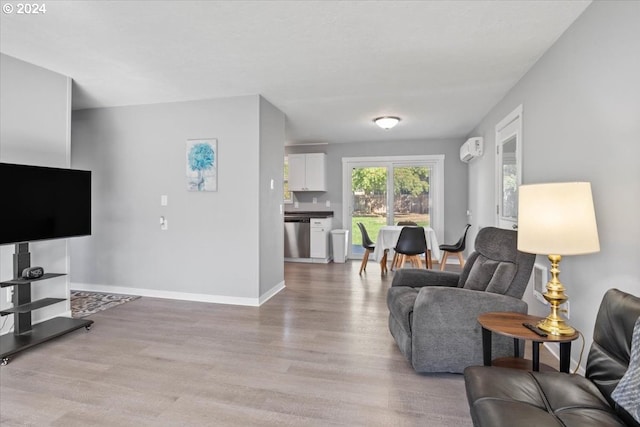 living room featuring light wood-type flooring and a wall mounted air conditioner