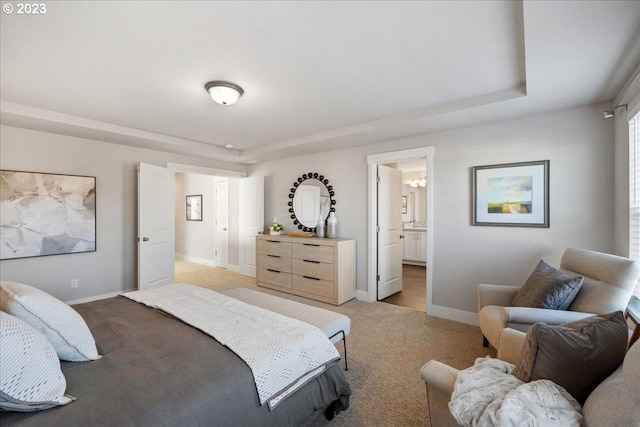 bedroom with ensuite bath and light carpet