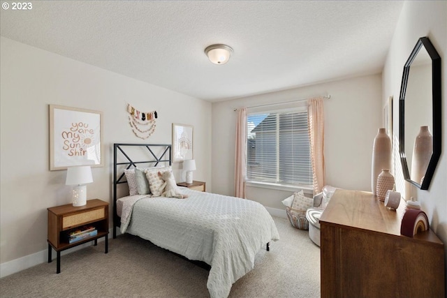 bedroom featuring light carpet and a textured ceiling