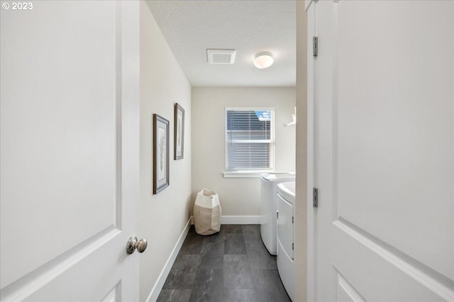 bathroom featuring vanity, washer and dryer, and a textured ceiling